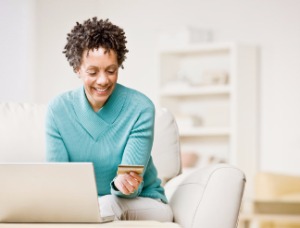 woman using credit card with laptop