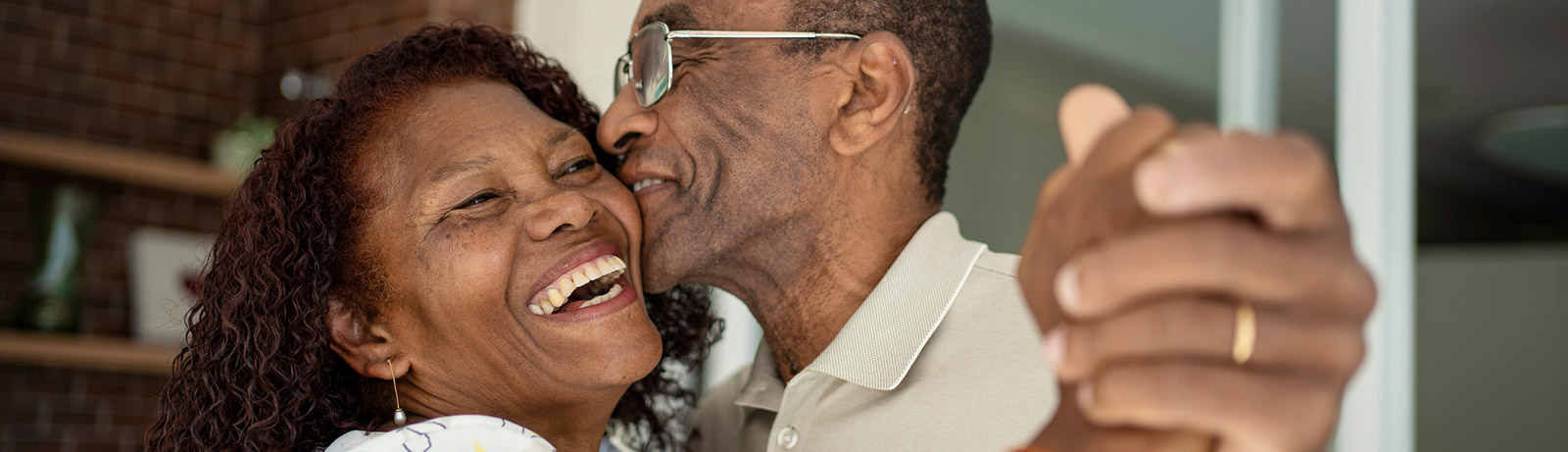 Senior couple dancing in living room