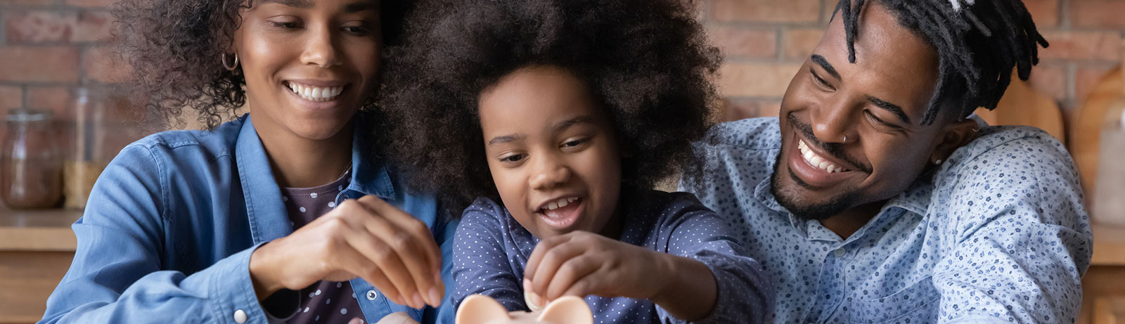 Young child putting money into piggy bank