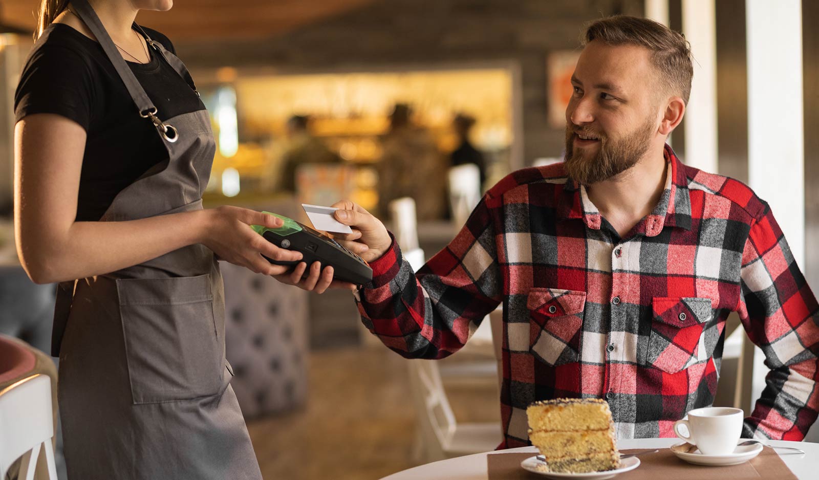 Man paying with debit card in cafe